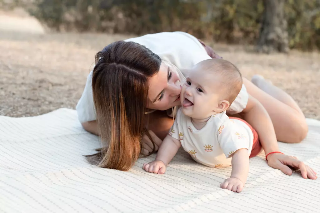Fotografía de bebés en montaña de Barcelona: Madre y bebé jugando en el suelo.