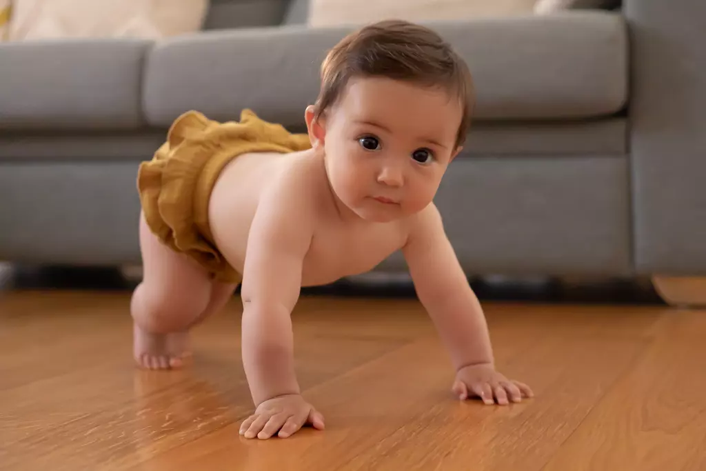 Fotografía de bebés en Barcelona: Bebé de pie apoyado, hito del desarrollo.