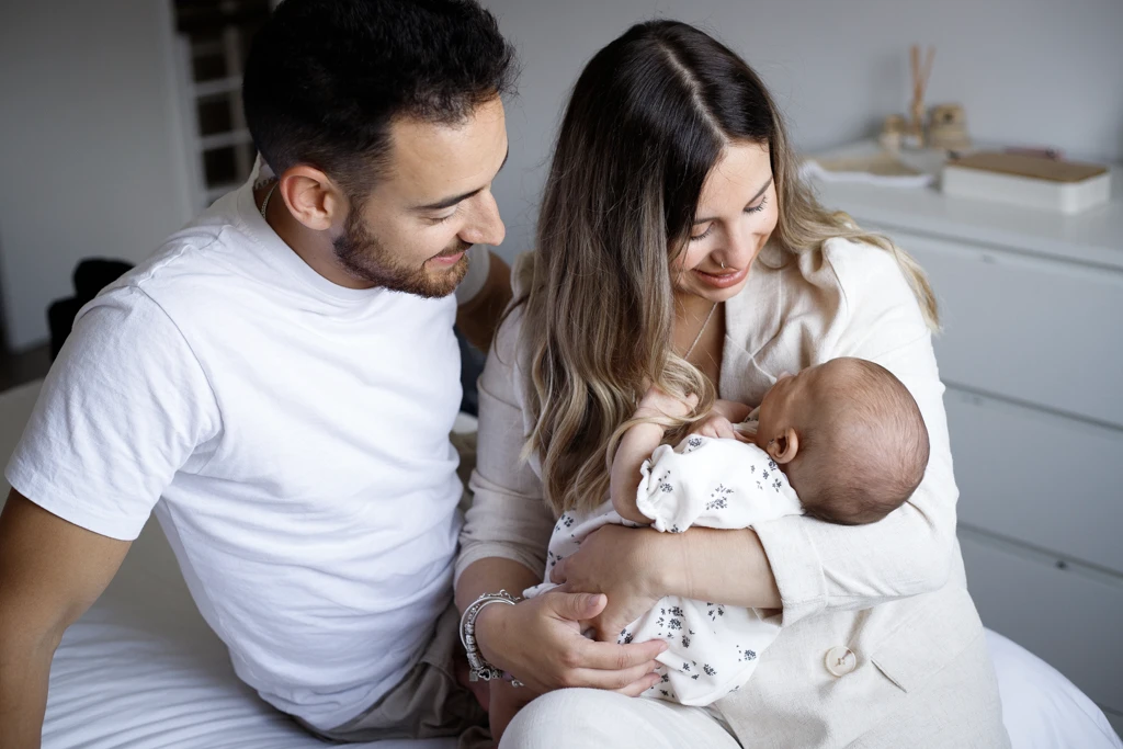 Fotografía de recién nacidos y familia en Barcelona: Padres con bebé, miradas de amor.
