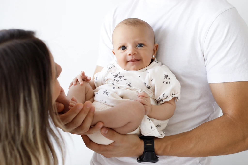 Fotografía de recién nacidos en Barcelona: Padres con su bebé en brazos, amor familiar.