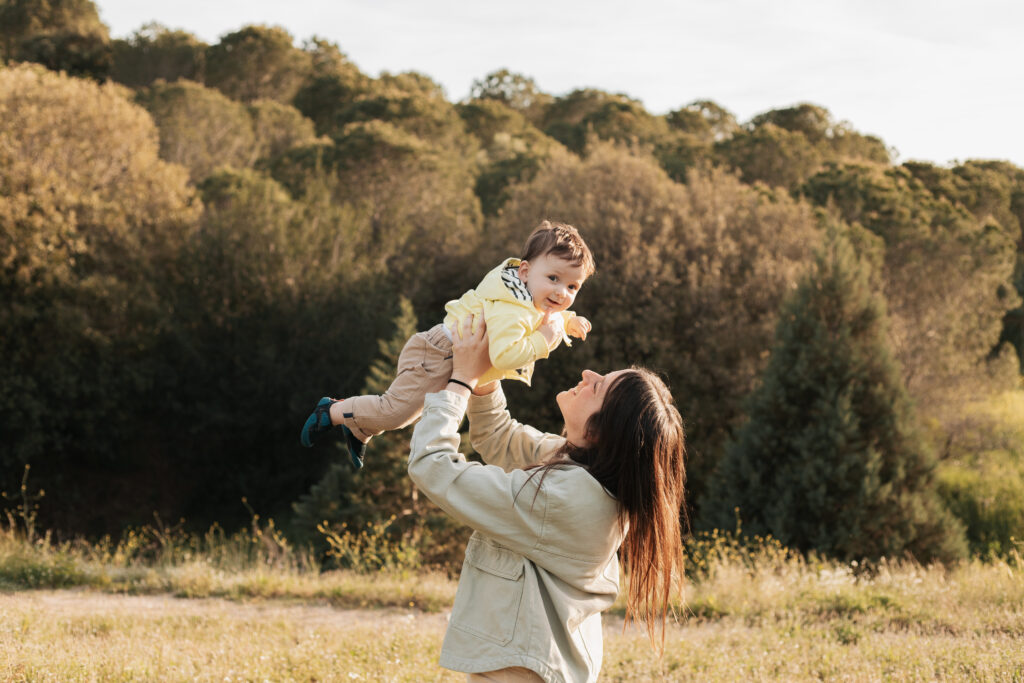 Madre levantando a su bebé con ternura durante una sesión al aire libre por el Día de la Madre en Barcelona