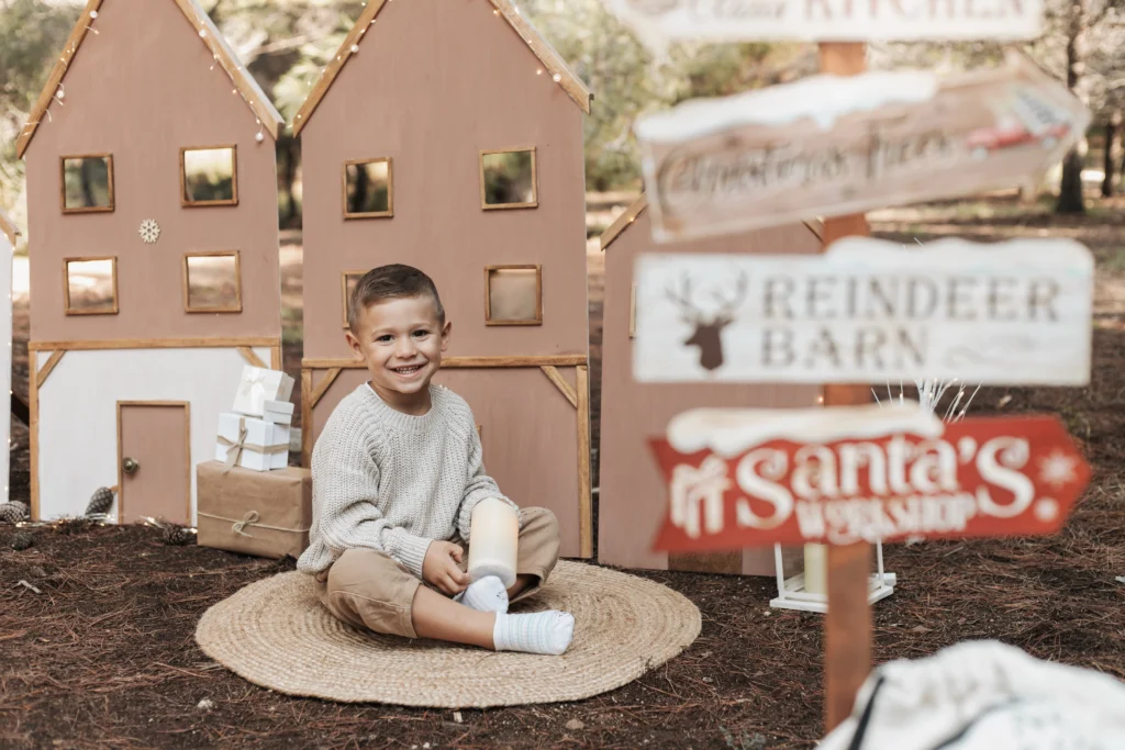 Niño en sesión de fotos de Navidad en exterior en Barcelona, con decorado festivo y ambiente natural
