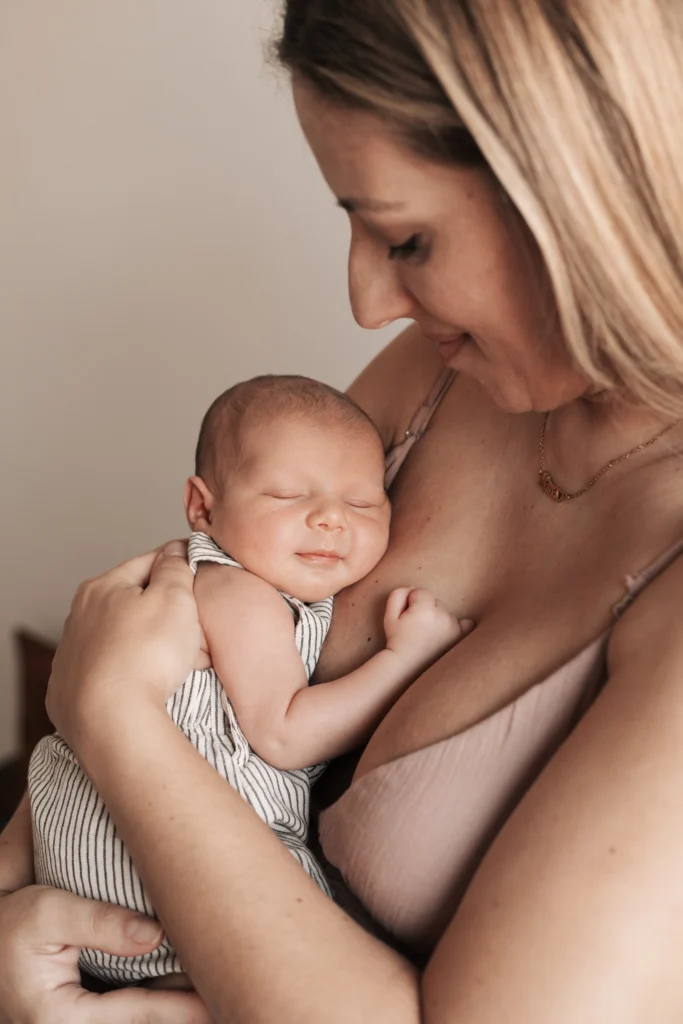 Sesión de fotos newborn en Barcelona con recién nacido bostezando en brazos de su madre durante un reportaje lifestyle.