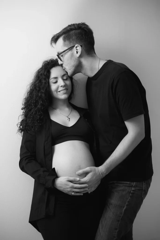 Retrato de pareja de maternidad en blanco y negro: fotografía íntima por Saray Ruiz. Fotografía de estudio íntima de embarazo en pareja en blanco y negro.