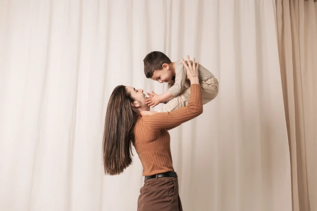Sesión fotográfica familiar Día de la Madre - Saray Ruiz Fotografía Madre e hijo jugando en el estudio para sesión de fotos del Día de la Madre. Estilo cálido y natural.