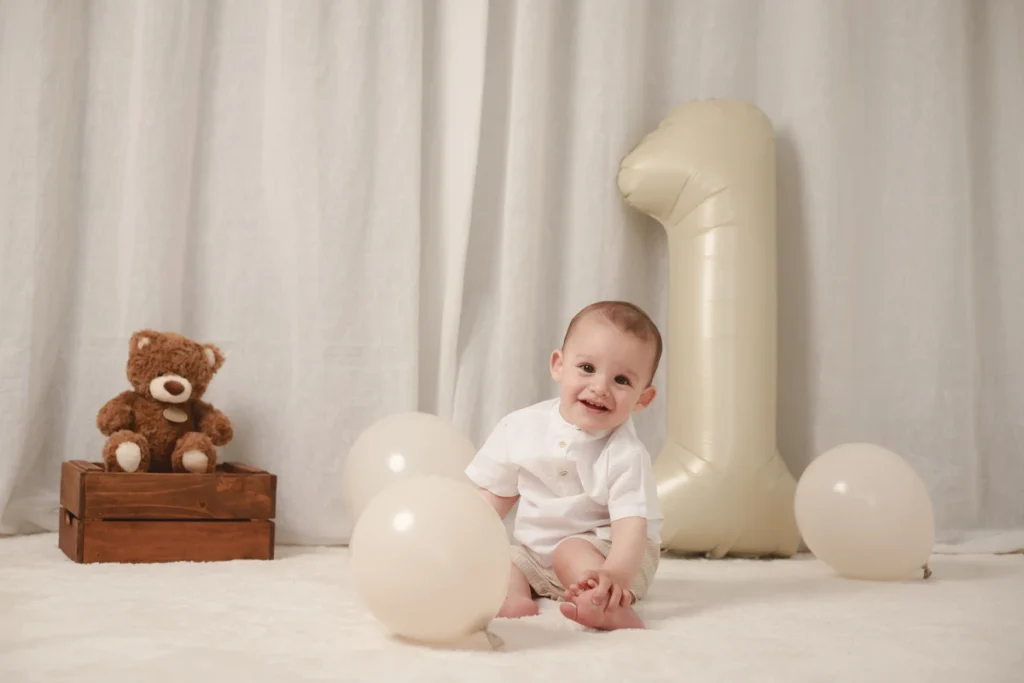 Reportaje de fotos 1 año en Santa Coloma de Gramenet, Barcelona. Sesión de fotos de primer cumpleaños para niño con globos y oso de peluche en estudio fotográfico.